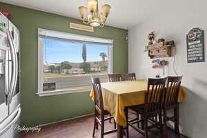 Dining space featuring a chandelier, wood finished floors, and baseboards