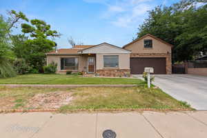 Ranch-style home featuring stucco siding, concrete driveway, stone siding, and a garage