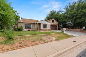 Ranch-style home with concrete driveway, stucco siding, stone siding, and a garage