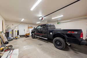 Garage featuring water heater and a garage door opener