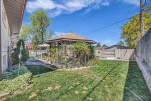 View of yard with a gazebo, a vegetable garden, and a fenced backyard