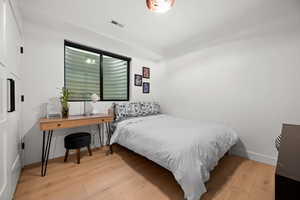 Bedroom with baseboards, visible vents, and wood-type flooring