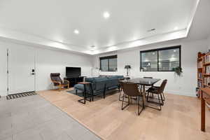 Dining room featuring light wood-style flooring, visible vents, a tray ceiling, baseboards, and recessed lighting