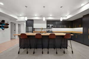 Kitchen featuring stainless steel appliances, light countertops, recessed lighting, and a sink