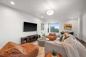 Living area featuring recessed lighting, a notable chandelier, and baseboards