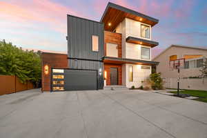 Modern home with fence, driveway, and an attached garage