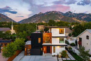 View of front of house featuring fence, a garage, a mountain view, a balcony, and concrete driveway