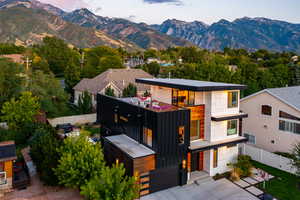 Contemporary home featuring a garage, a mountain view, fence, and board and batten siding