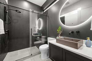 Bathroom featuring tile patterned floors, a shower stall, toilet, and vanity