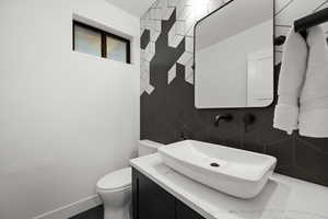 Bathroom with vanity, toilet, and baseboards
