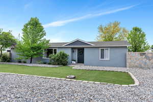 Ranch-style home featuring stucco siding, a front lawn, and a shingled roof