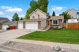 Split level home featuring concrete driveway, brick siding, an attached garage, and a shingled roof