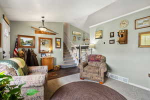 Living area featuring stairway, lofted ceiling, and baseboards
