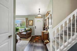 Entrance foyer with wood finished floors and stairway