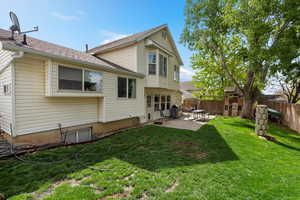 Rear view of property featuring a patio area and a shingled roof