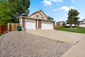 Traditional-style home with brick siding, an attached garage, and driveway