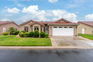 View of front of property featuring a tile roof, driveway, and stucco siding