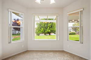 Spare room featuring carpet floors and baseboards