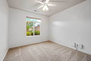 Carpeted empty room with baseboards and a ceiling fan