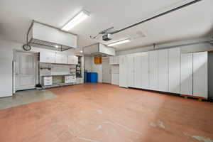 Garage with a garage door opener and freestanding refrigerator