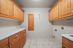 Laundry area with cabinet space, washer hookup, electric dryer hookup, and baseboards