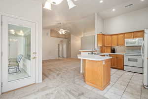 Kitchen featuring white appliances, a sink, arched walkways, a peninsula, and light countertops