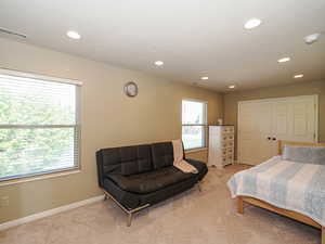 Bedroom with light carpet, recessed lighting, and baseboards