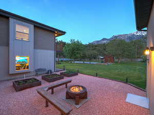 View of patio / terrace featuring a mountain view, a vegetable garden, and a fire pit