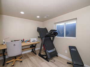 Workout area with light wood-style flooring, baseboards, and recessed lighting