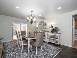 Dining space featuring a chandelier, baseboards, recessed lighting, and stairs