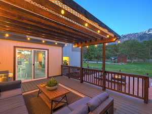 Wooden deck featuring a pergola, a mountain view, a yard, and an outdoor hangout area