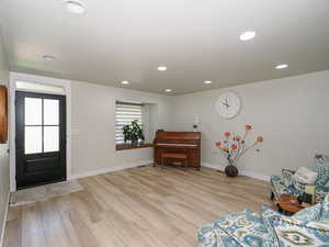 Foyer featuring light wood-style flooring, baseboards, and recessed lighting