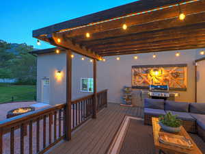 Deck with an outdoor living space with a fire pit and a grill