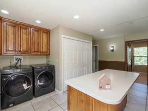 Clothes washing area featuring independent washer and dryer, cabinet space, light tile patterned floors, and recessed lighting