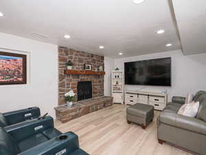 Living area with light wood finished floors, a fireplace, and recessed lighting