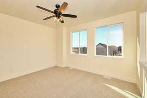 Owner's room with light colored carpet, baseboards, a ceiling fan, and a textured ceiling