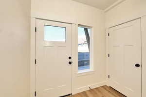 Entryway with plenty of natural light, light wood-style flooring, and baseboards