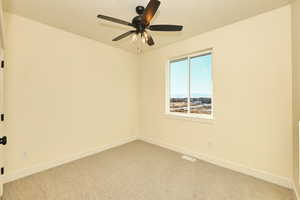 Bedroom featuring light carpet, baseboards, and ceiling fan