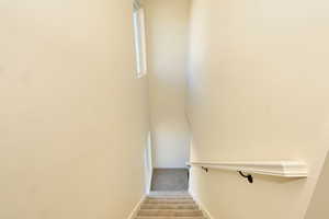 Stairway featuring carpet and baseboards
