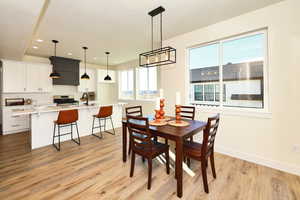 Dining area featuring light wood finished floors, recessed lighting, baseboards, and a textured ceiling