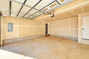 Garage with electric panel and a garage door opener