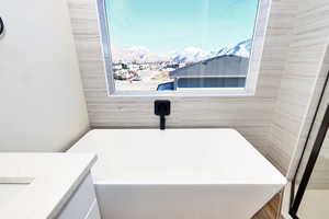 Full bath with a mountain view, a freestanding tub, and vanity