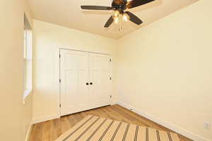 Unfurnished bedroom featuring light wood finished floors, baseboards, a closet, and a ceiling fan