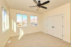 Bedroom featuring light colored carpet, baseboards, a mountain view, and a closet
