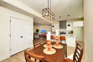 Dining area with light wood-type flooring, baseboards, recessed lighting, and a textured ceiling