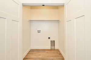 Laundry room featuring hookup for an electric dryer, hookup for a washing machine, light wood-style floors, and baseboards