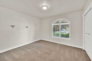 Carpeted empty room featuring baseboards