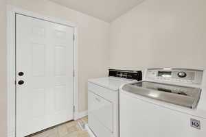 Laundry area with independent washer and dryer and baseboards