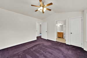 Unfurnished bedroom with carpet flooring, vaulted ceiling, baseboards, connected bathroom, and a sink