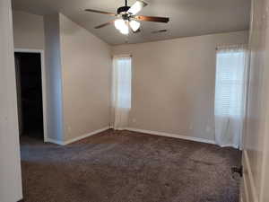 Unfurnished room with a ceiling fan, carpet, baseboards, and lofted ceiling